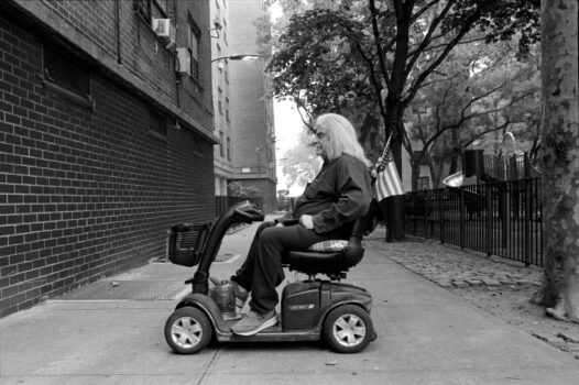 Man in Wheelchair with American Flag, Chelsea, NYC